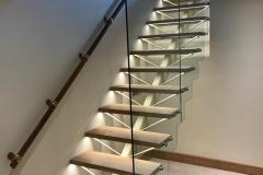 Bespoke spine back staircase with under tread lighting and glass screen